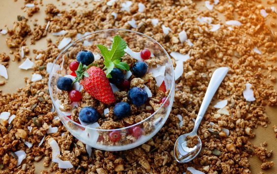 A top view of a healthy granola breakfast with fresh berries and yogurt in București.